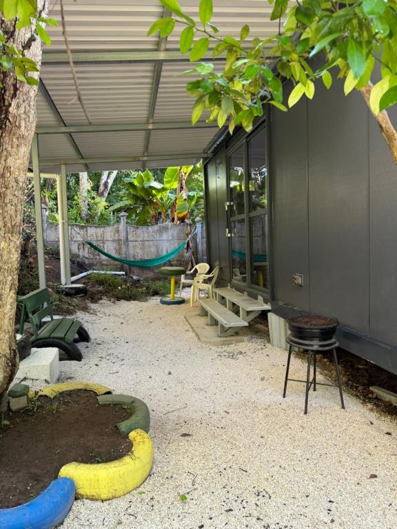 a patio with a hammock and a house at Family Wolf - El Chorro in Paquera