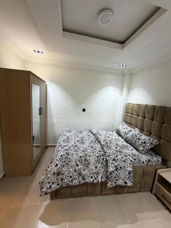 a bedroom with a bed with a comforter on it at The Pointe Apartments in Agege