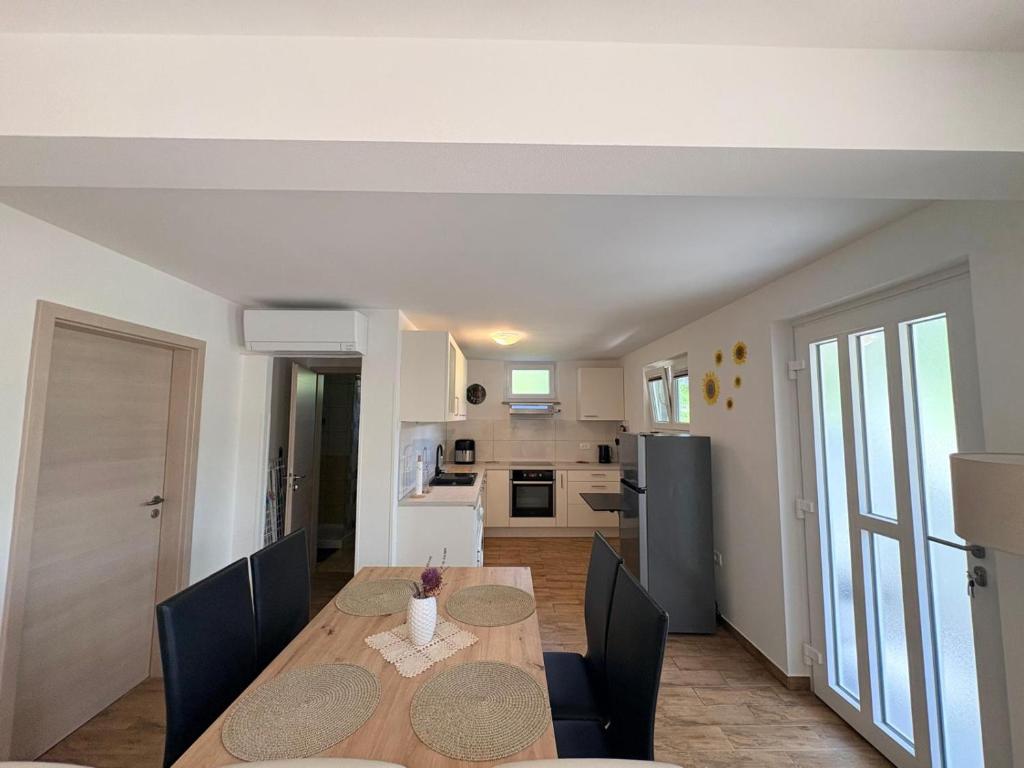 a kitchen and dining room with a table and chairs at Apartma Zari in Marezige