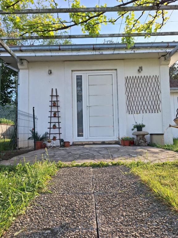 a white house with a white garage door at Small house in Danilovgrad