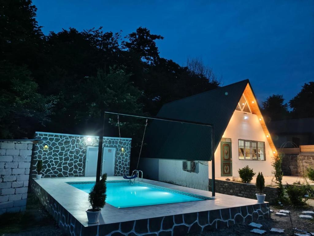 a swimming pool in front of a house at night at Ismayilli in İsmayıllı