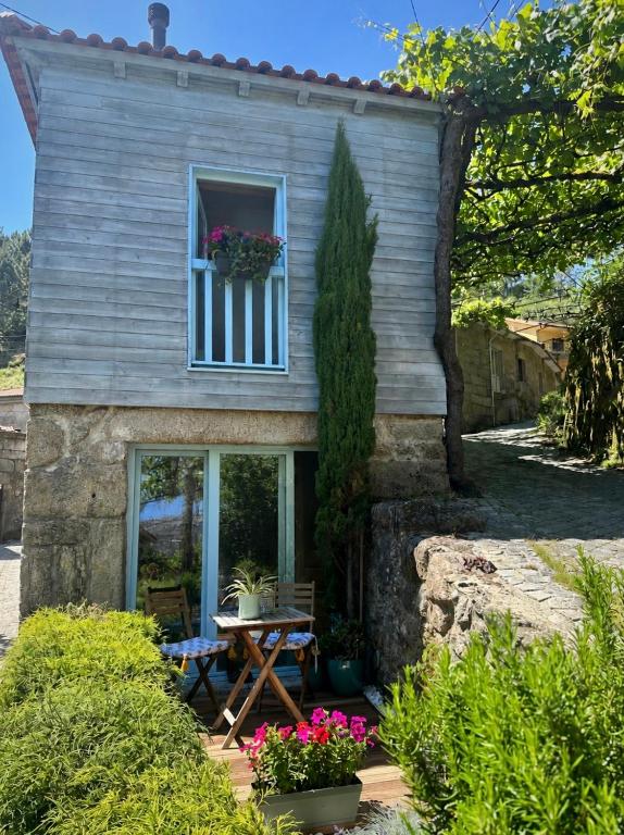 a small house with a table and a window at Casa Sulfato in Campo do Gerês