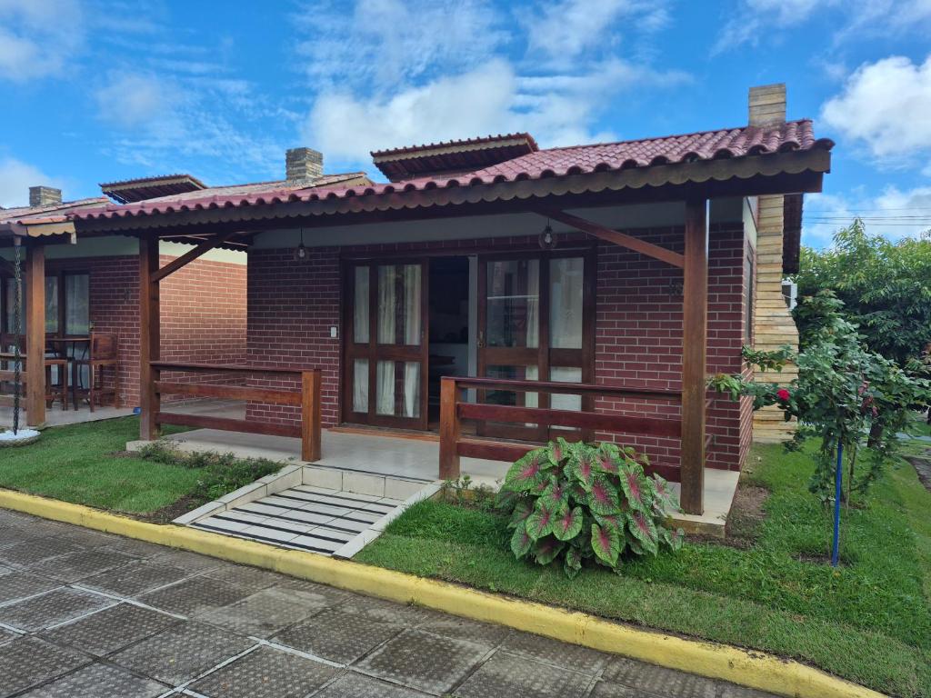 a small brick house with a porch at Privê Monte Serrat, Chalé 18 in Gravatá