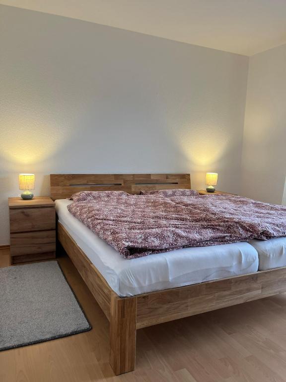 a bedroom with a bed with two lamps on it at Ferienwohnung Tor zum Oberwald in Herbstein