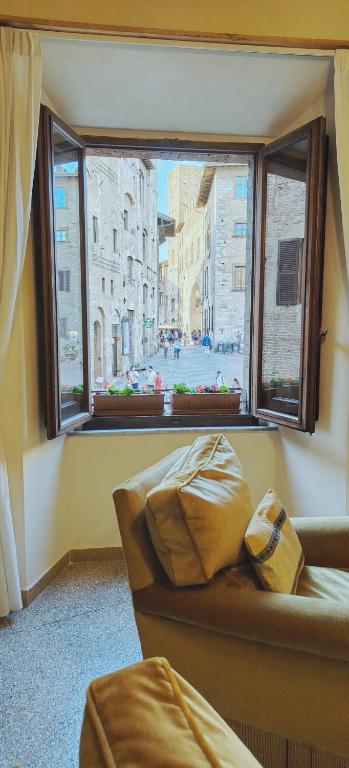 a living room with a couch and a large window at Casa Becci Central Large & Sunlit Historical Flat in San Gimignano