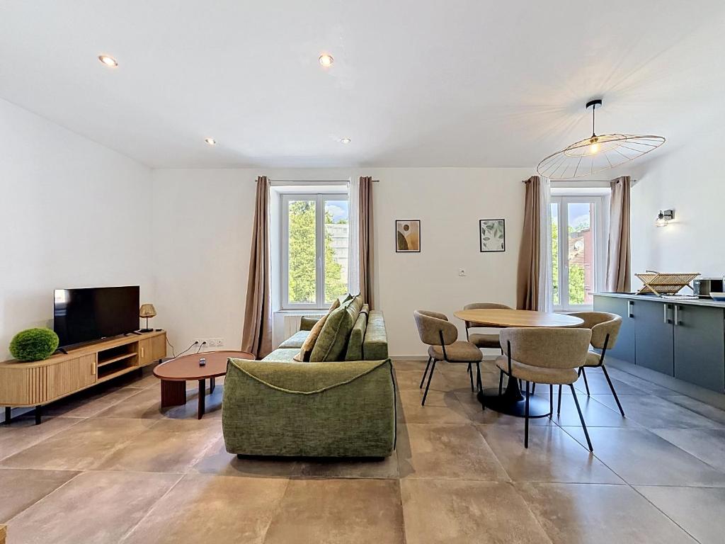 a living room with a couch and a table at L'Arrière Cour in Montbéliard