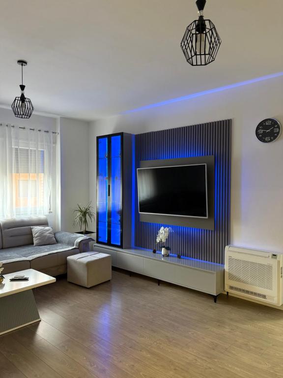 a living room with a couch and a flat screen tv at Mme apartment in Kamëz
