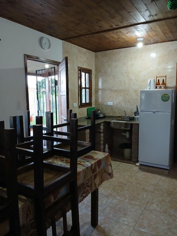 a kitchen with a table and a white refrigerator at Cabañas amanecer alegre in Salta