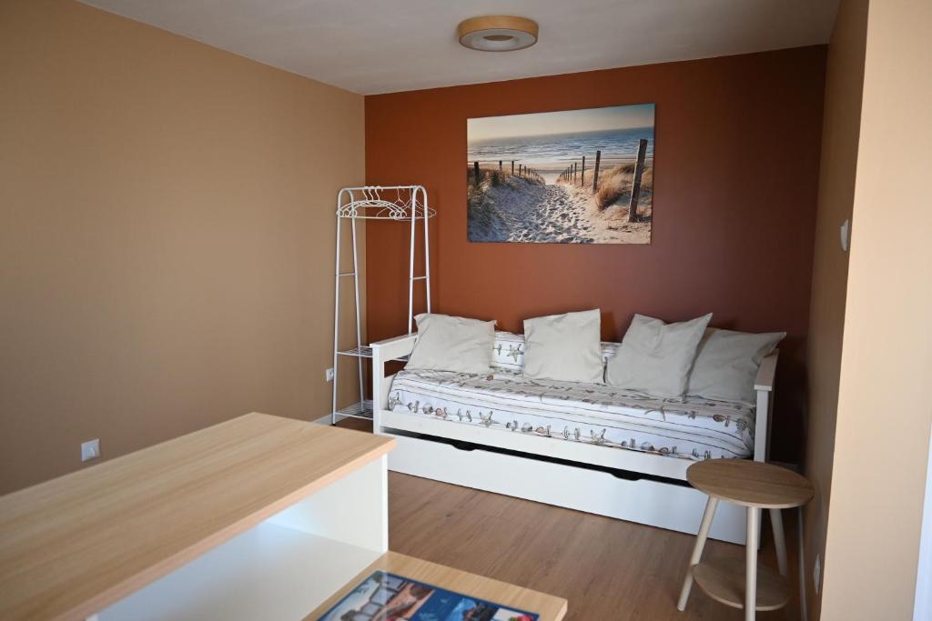 a bedroom with a bed with a picture on the wall at Studio proche océan pour Deux personnes in Longeville-sur-Mer