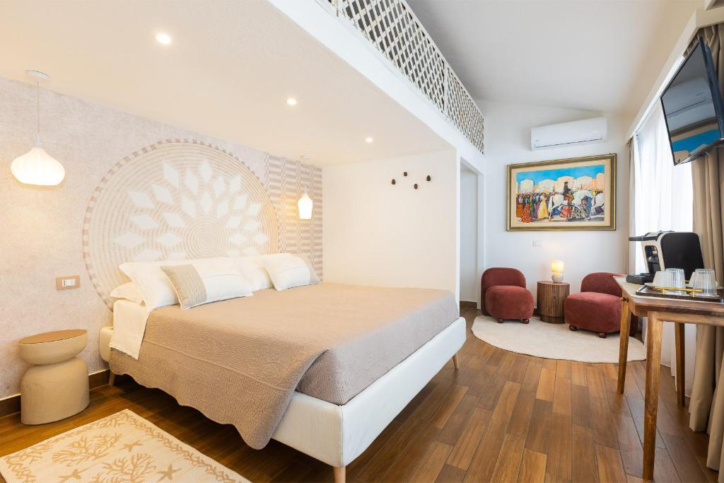 a bedroom with a bed and a living room at PALMASERA CHARMING - Rooms & Suites in Cala Gonone