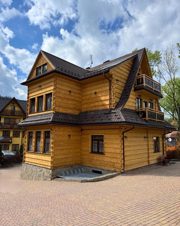 a large wooden house with a gambrel roof at Kowali Wierch - blisko Centrum i Dworca PKP in Zakopane