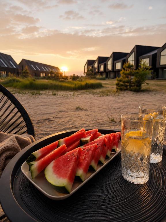 a plate of watermelon on a table with a drink at Vėjų kraštas in Svencelė