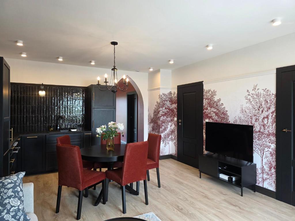 a dining room with a table and chairs and a television at Apartamenty Stargardt in Stargard
