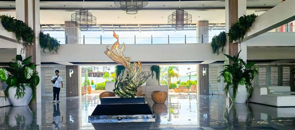 a person walking through a lobby with a fountain in a building at Althea's Horizon Stay - Primeworld District in Pajak