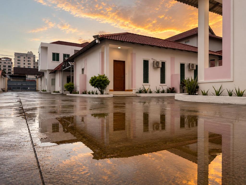 a house is reflected in a puddle of water at Ah Gong Boutique Bungalows in Sihanoukville