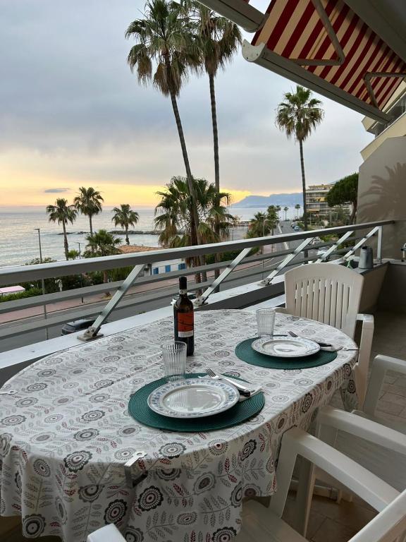 a table with a bottle of wine on a balcony with the ocean at Casa Lea in Ventimiglia