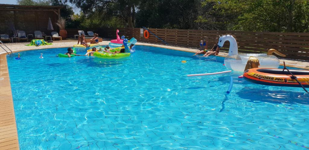 a group of children playing in a swimming pool at 2BR Family Gouvia – Apt 2 in Gouvia