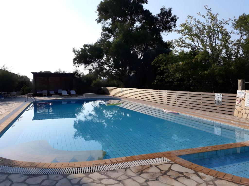 a large swimming pool with a fence around it at Value Stay for 4 – Apt 11 in Gouvia