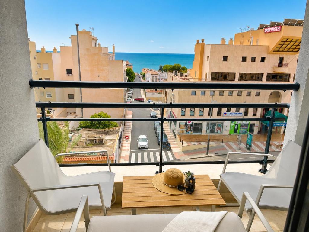 a balcony with chairs and a table and a view of a city at Horizon Santa Monica in Aguadulce