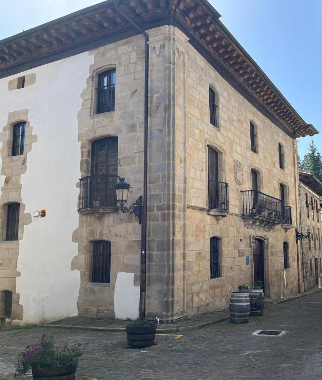 a large stone building with black doors and windows at Palacio Soran in Leintz-Gatzaga