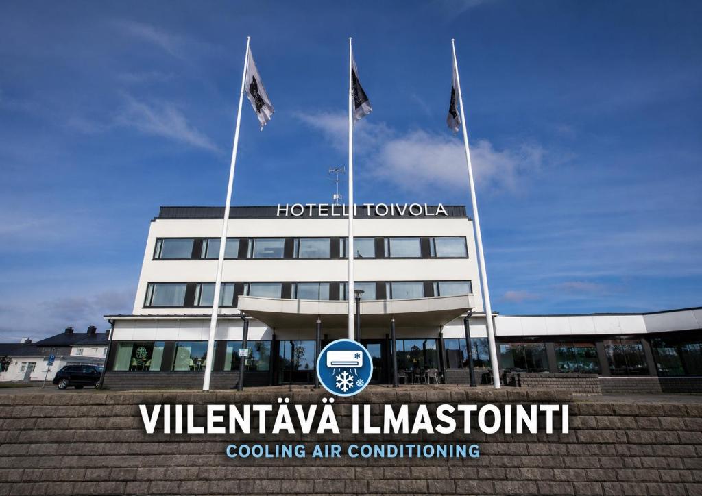 a building with two flags in front of it at Hotelli Toivola in Kemi
