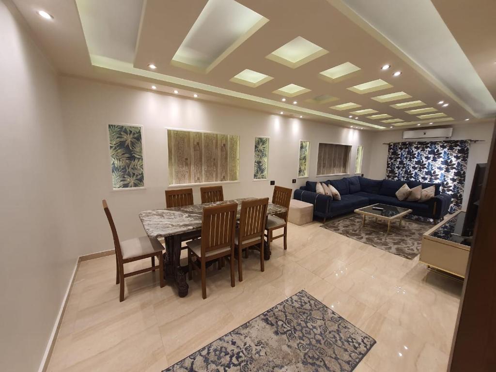a living room with a table and chairs and a couch at Alex dream in Alexandria