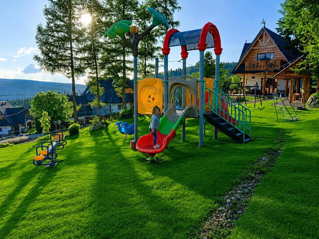 a child playing on a playground in a yard at Domek u Justyny in Kościelisko
