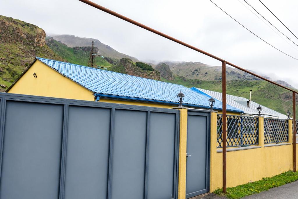 a building with blue garage doors with mountains in the background at Villa Arsha in Arsha