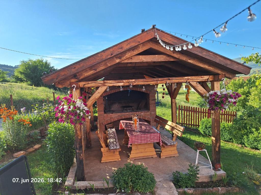 a wooden gazebo with a table in a garden at Rural accommodation Vidovic in Ugarci