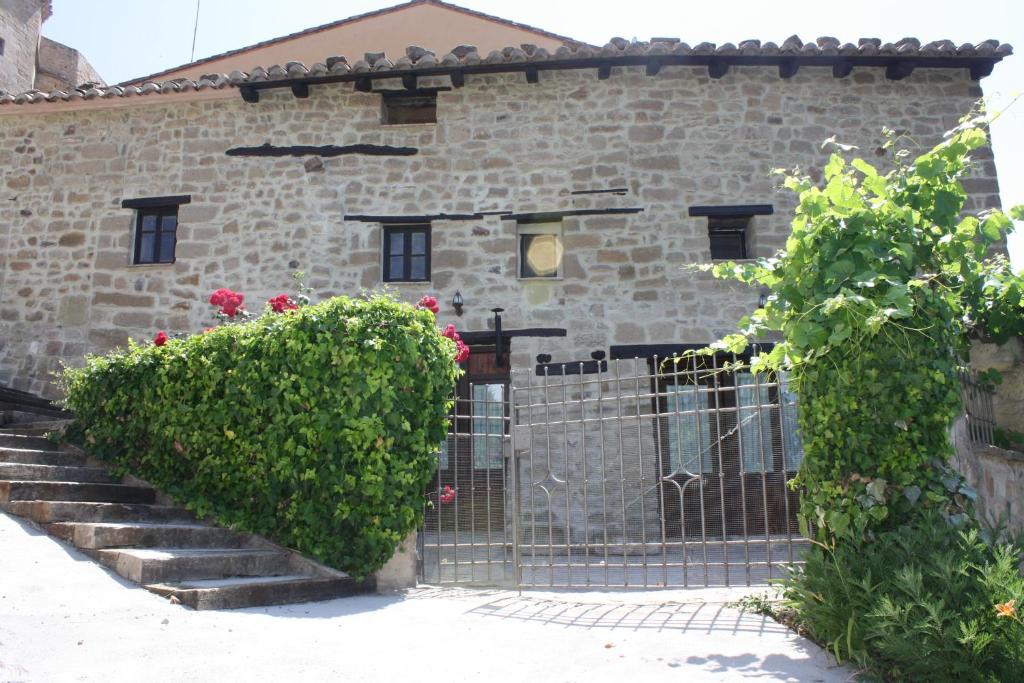 een stenen gebouw met een poort en bloemen bij Apartamentos Rio Mora in Mora de Rubielos