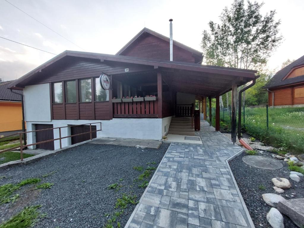a house with a walkway in front of it at Penzión Ostrva in Vyšné Hágy