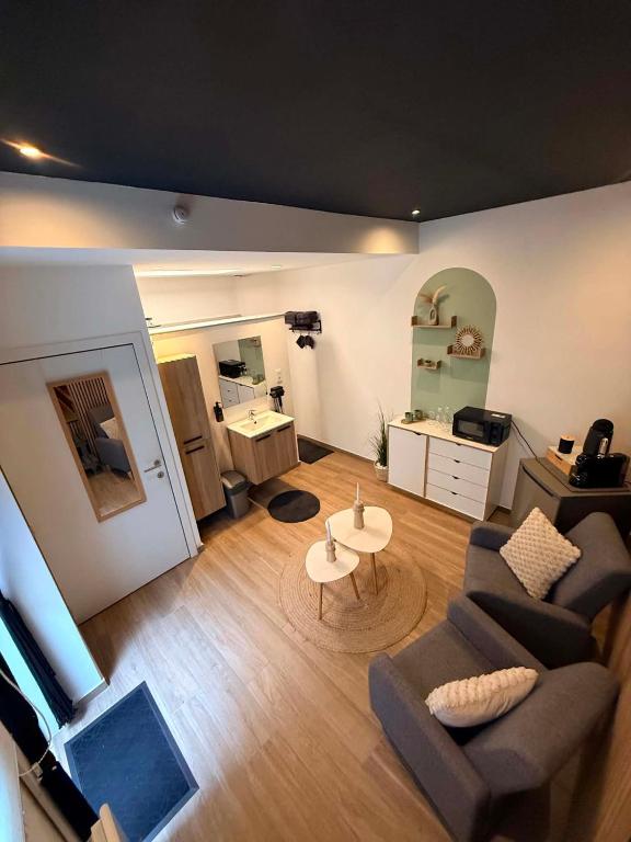 a living room with a couch and a table at Au bât Tournai chambre zen in Tournai