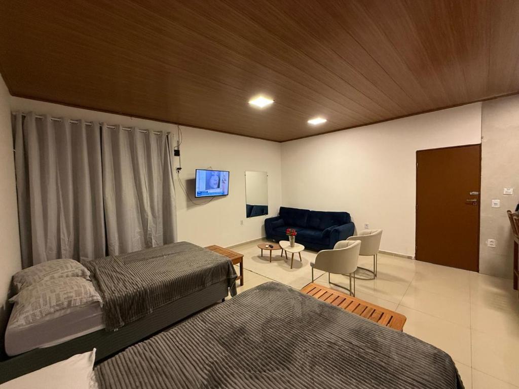 a bedroom with two beds and a blue couch at Condomínio Feitosa Barros II in Maceió