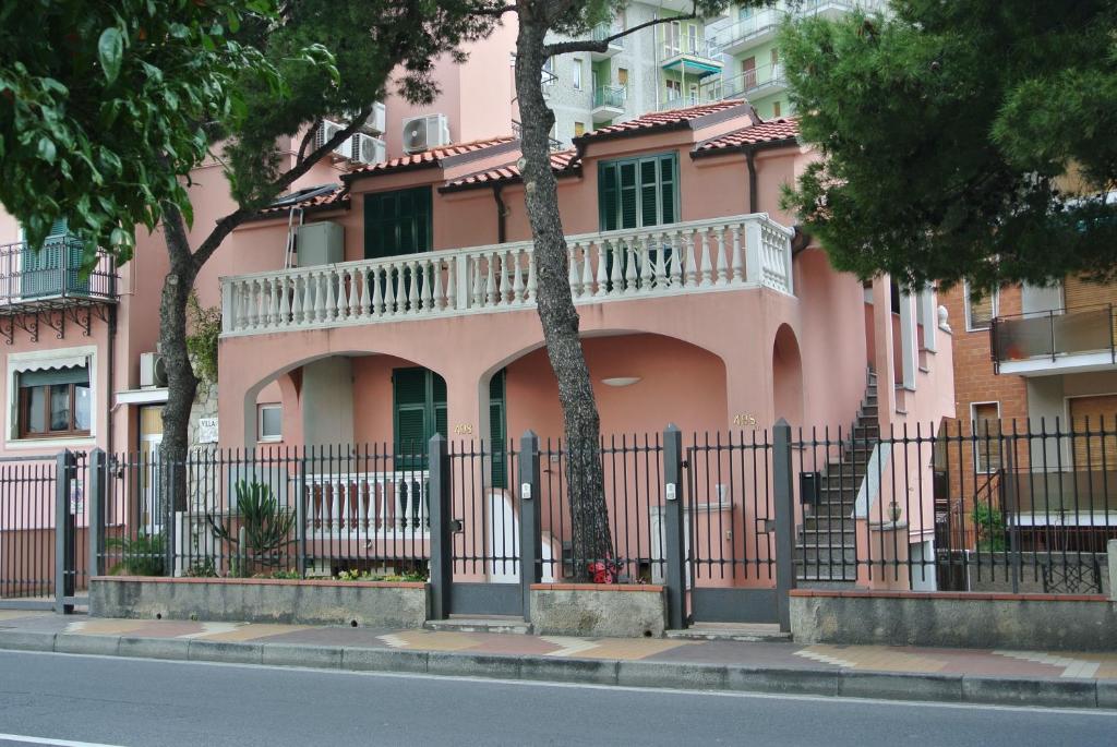 a pink house with a fence in front of it at Casa Selly in Loano