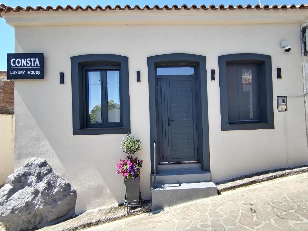 a white house with a blue door and windows at CONSTA Luxury House in Mantamádos