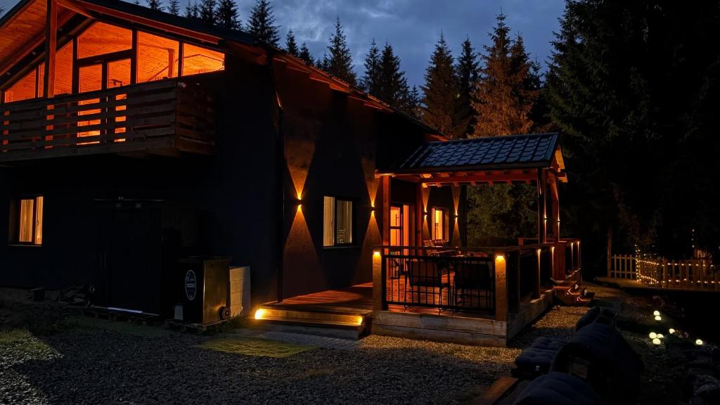 a house with a gazebo at night at Greystone Cabin in Măguri-Răcătău
