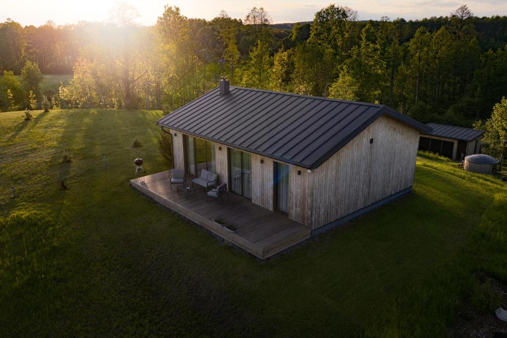 a small cabin with a deck in a field at Lapės Kalva in Rimėnai