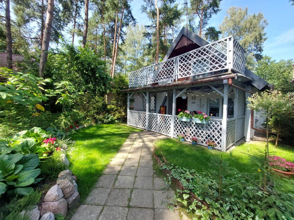 a house with a white deck and a yard at Przystań Arizona Ostróda in Ostróda
