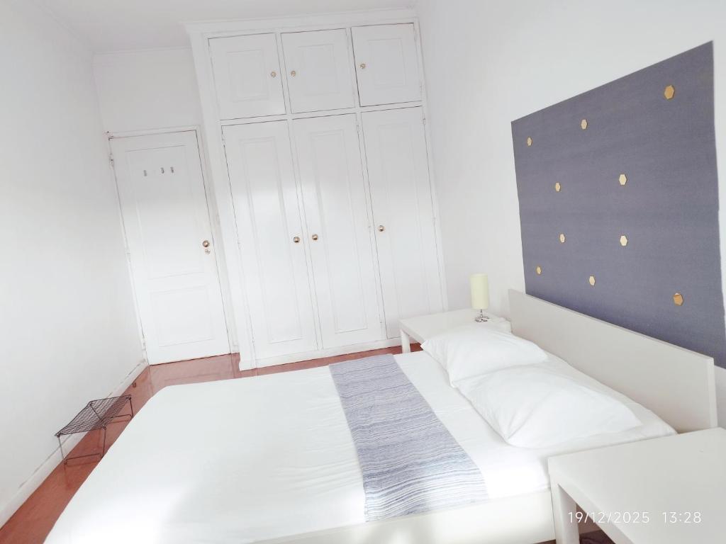 a bedroom with a white bed and white cabinets at Estádio da Luz Room in Lisbon