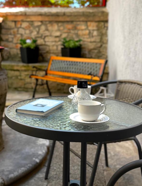 a table with a cup of coffee and a book at Apartment Marija in Vodnjan