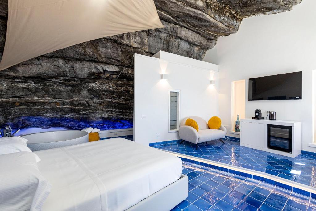 a bedroom with a bed and a stone wall at Le Suite dei Pescatori in Praiano