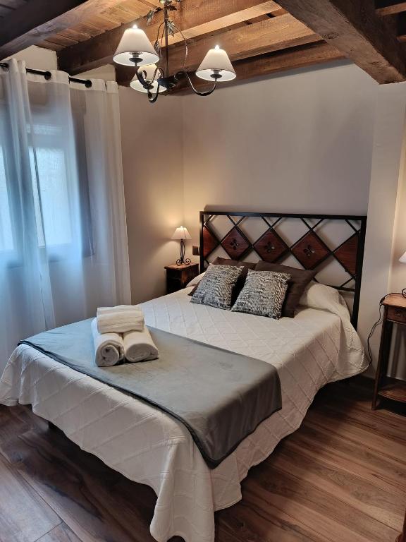a bedroom with a large bed with two towels on it at Apartamentos EL Wala in Hervás