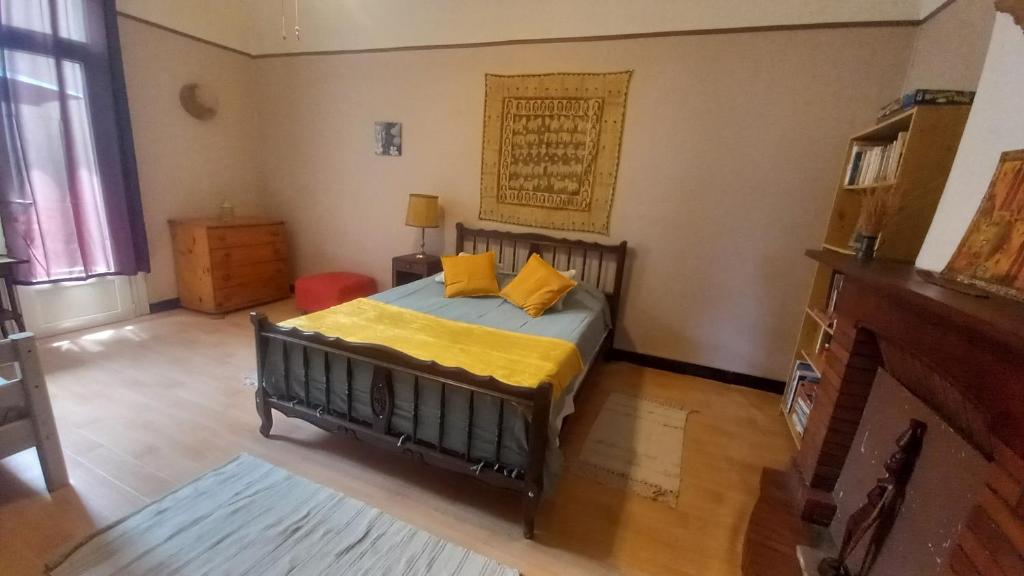 a bedroom with a bed with yellow pillows on it at Chez Valérie côté Sud in Saint-Jean-du-Gard