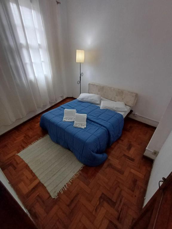 a bedroom with a blue bed with two boxes on it at Apt Petrópolis - Imperial in Petrópolis