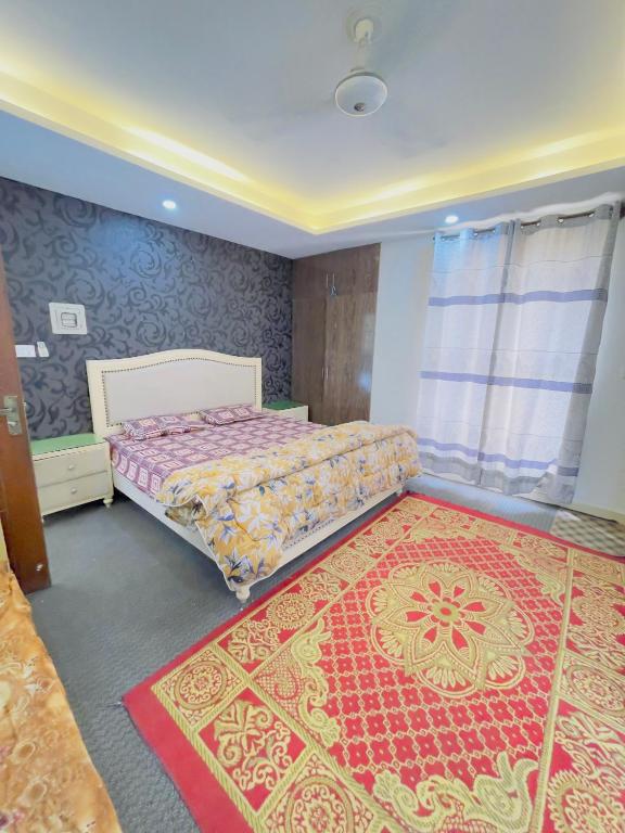 a bedroom with a bed and a red rug at Stay lux yellow in Islamabad
