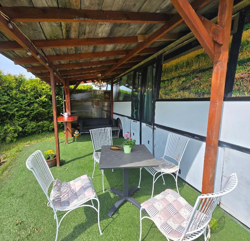 a patio with a table and chairs on the grass at Atomi CountryBus in Aucugals