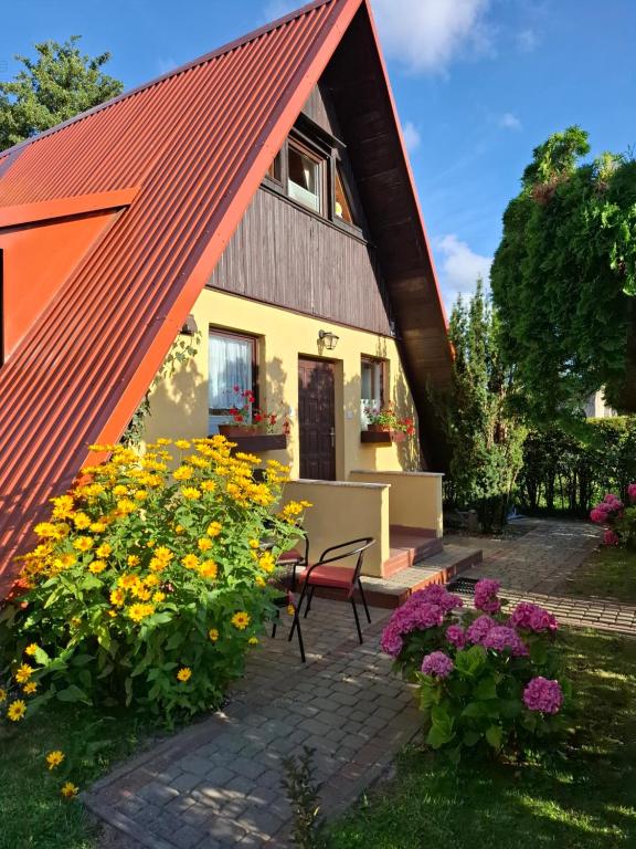 a house with a red roof and some flowers at U Cecylii in Rowy