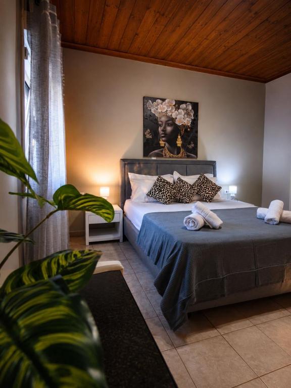 a bedroom with a bed with a portrait of a woman at Sunray Separate Villa in Skala Sotiros
