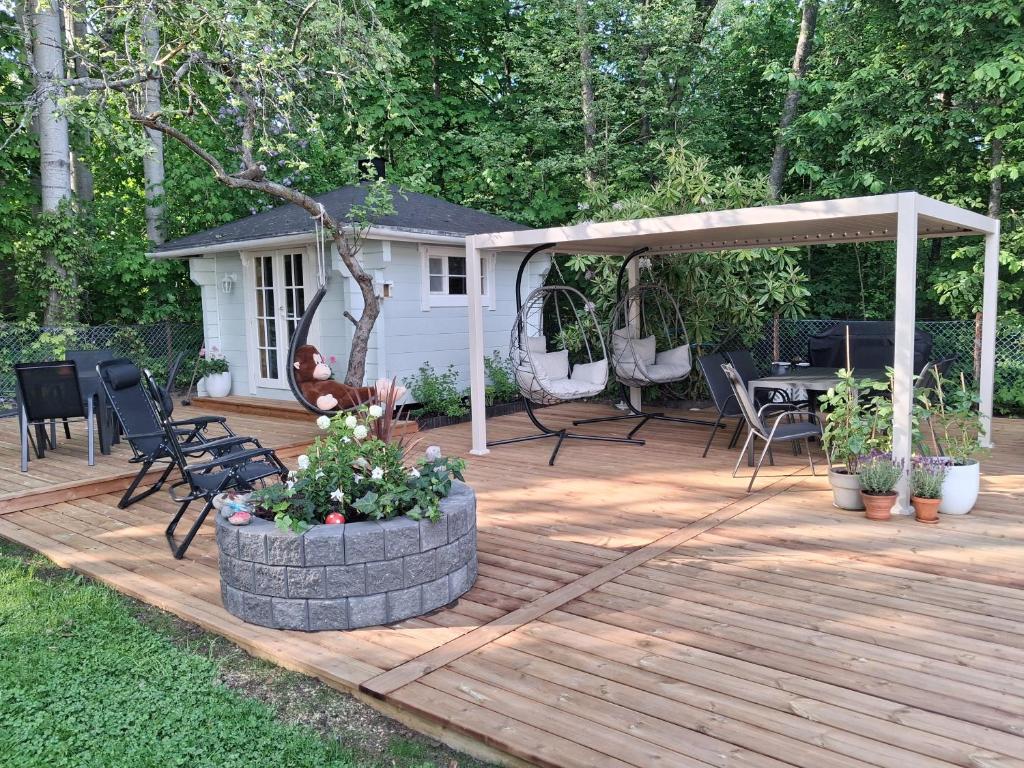 a wooden deck with a pergola and a table and chairs at Aittamajotus casinonsaari in Savonlinna