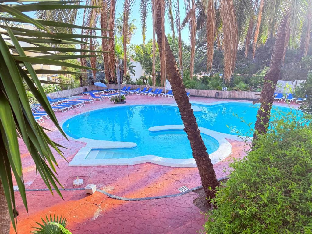 a large swimming pool with palm trees in a resort at Cap Salou Binda Mar Apartment in Salou
